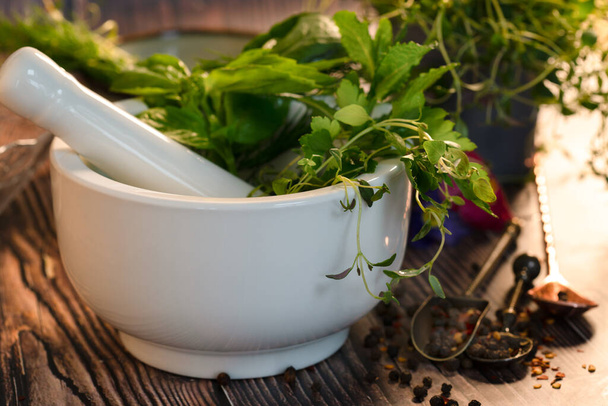 Fresh herbs in mortar and pestle - Photo, Image