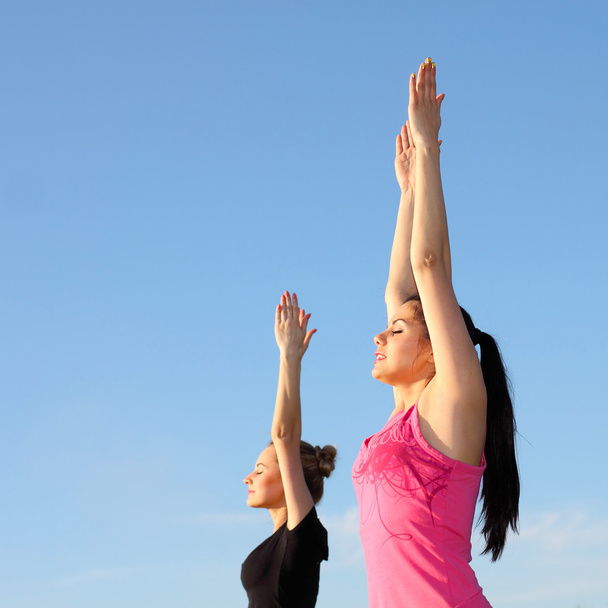 twee vrouwen doen yoga buiten - Foto, afbeelding