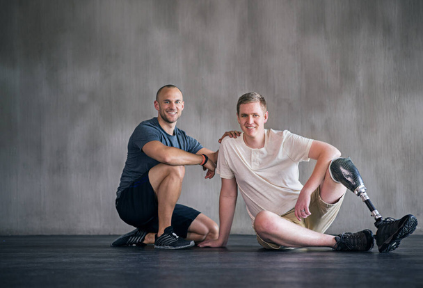 Portrait of positive recovery. Portrait of a male amputee and his physiotherapist. - Foto, afbeelding