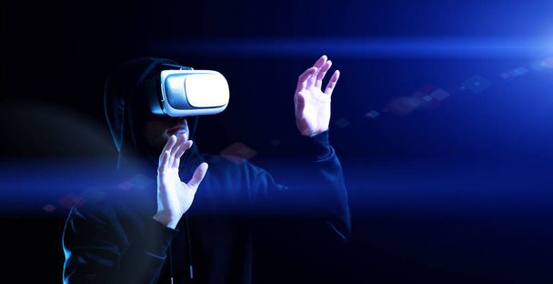 Vr maschera la realtà virtuale. Giovane uomo in casco digitale per 3d gioco di realtà virtuale su sfondo scuro. Studio e mondo virtuale nella simulazione 3D - Foto, immagini