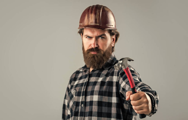 handsome bearded guy with beard and moustache hold hammer, selective focus, builder - Photo, Image