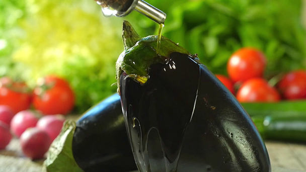 Pouring olive oil over an eggplant - Footage, Video