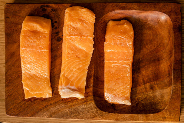 filetes de salmón crudo en un plato de madera - Foto, Imagen