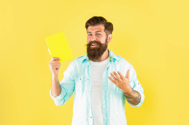 happy bearded man presenting book on yellow background, advertisement - Foto, Bild