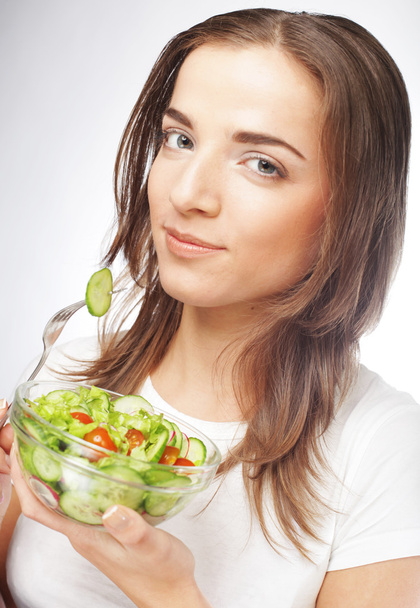 Chica con una ensalada sobre un fondo blanco
 - Foto, imagen