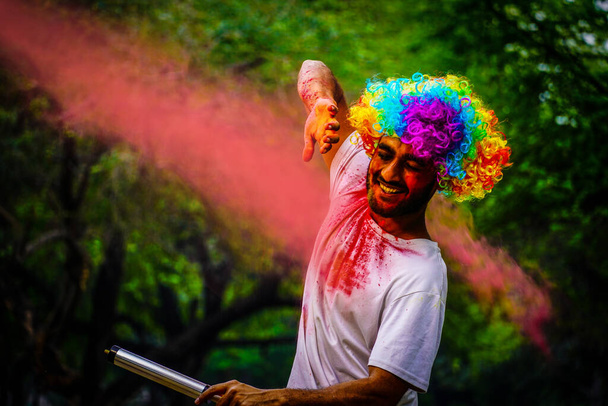 Šťastný mladý chlapec na holi barevný festival barevný prášek exploze. - Fotografie, Obrázek