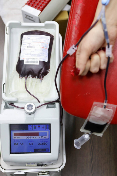 Donante de sangre. Preparación y donación de sangre para las necesidades de los pacientes. Una mujer toma sangre para su análisis. Analizador de sangre de hardware. Laboratorio sanguíneo. - Foto, imagen