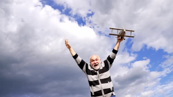 Счастливый старик представьте полет на модельном самолете в небе, путешествие - Кадры, видео