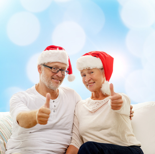 gelukkige senior paar in santa helper hoeden - Foto, afbeelding