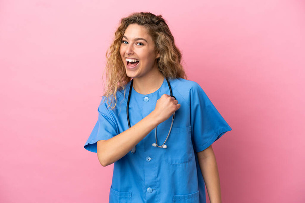 Young surgeon doctor woman isolated on pink background celebrating a victory - Foto, Imagem