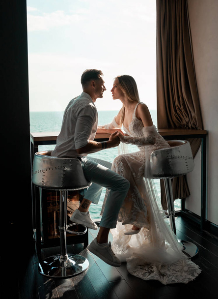 Man and woman studio shoot with decor kisses, hugs. Happy couple. Lovers bride and groom in luxury decoration. Bride and groom together. Couple hugging. Newlyweds at wedding day - 写真・画像