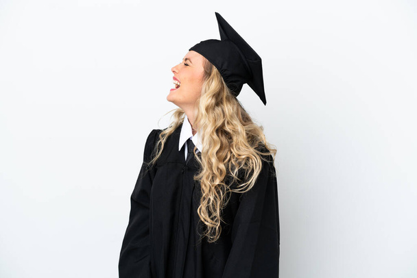 Young university graduate woman isolated on white background laughing in lateral position - Fotoğraf, Görsel