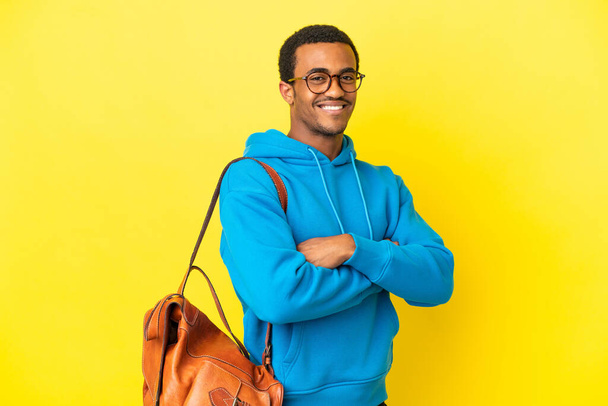 African American student man over isolated yellow background with arms crossed and looking forward - Valokuva, kuva