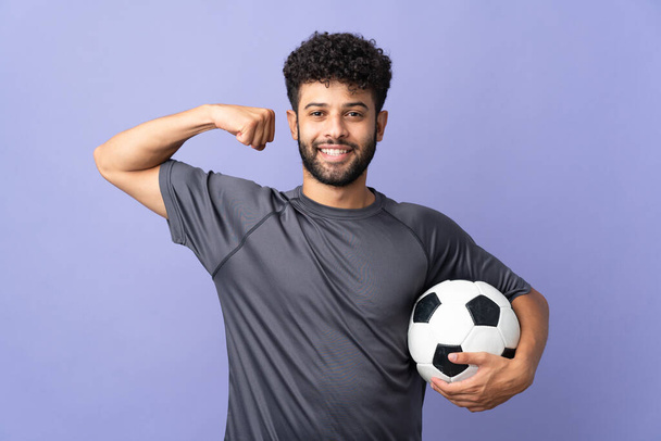 ハンサムなモロッコの若いサッカー選手男上の孤立した上に紫の背景に強いジェスチャーをやって - 写真・画像