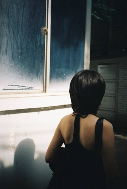 girl in a black dress with a window - Фото, зображення