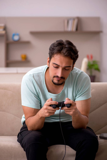 Giovane uomo che gioca joystick giochi a casa - Foto, immagini