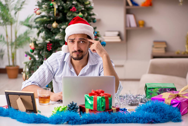 Young man celebrating Christmas at home alone - Фото, изображение