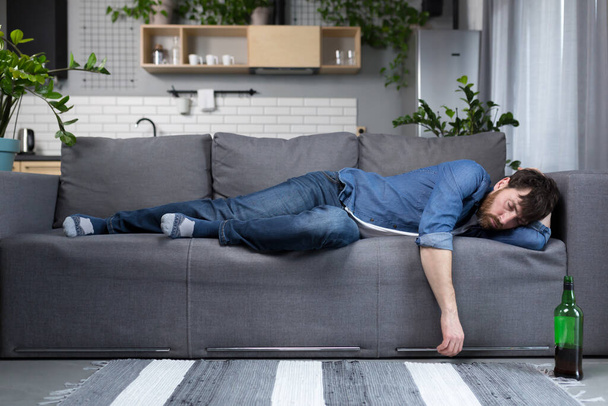 Drunk man sleeping on the couch in the kitchen - Valokuva, kuva
