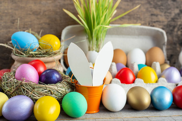 multi colors painted easter eggs in colored buckets with bunny rabbit ears. Happy Easter Card - Foto, Imagem