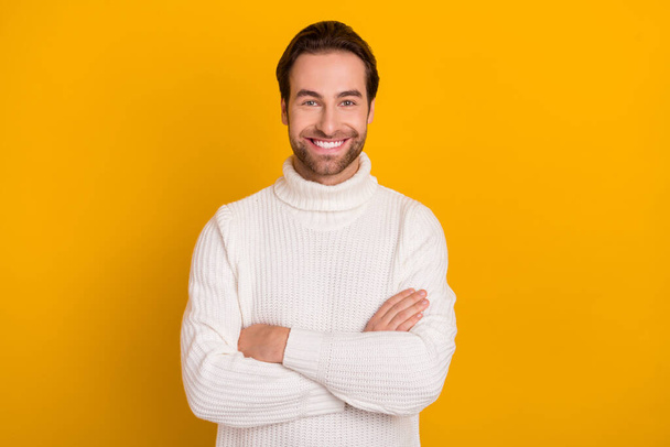 Photo of self-assured cheerful guy crossed hands beaming smile wear white sweater isolated yellow color background - Zdjęcie, obraz