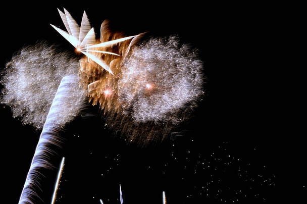 Porciones de diversos fuegos artificiales en cielo nocturno con luces de colores y fuego  - Foto, Bild