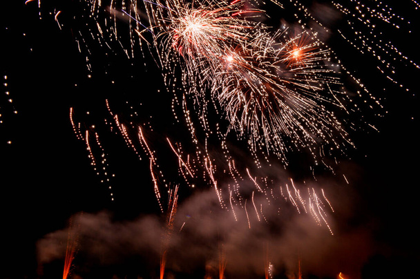 Porciones de diversos fuegos artificiales en cielo nocturno con luces de colores y fuego  - Φωτογραφία, εικόνα