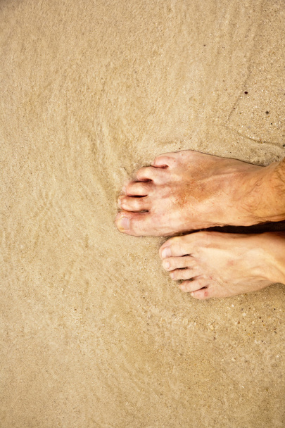 pieds d'un homme dans le sable fin entouré d'eau salée
 - Photo, image