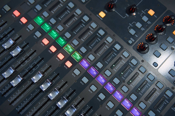 Professional audio mixing console. Mixer. Pro audio mixing board faders and knobs. Static shot of multi-track music recording equipment faders and sliders.  - Photo, image