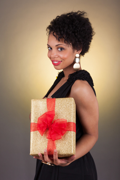 Young African American woman holding a gift  - Fotoğraf, Görsel