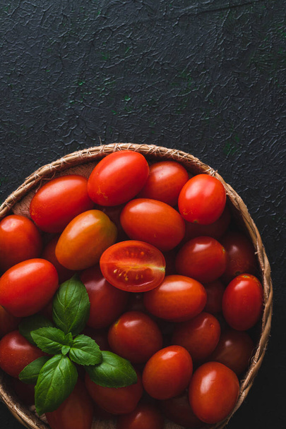 Корзина помидоров черри на тёмном фоне - Фото, изображение