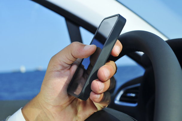Hombre usando un teléfono inteligente en un coche
 - Foto, Imagen