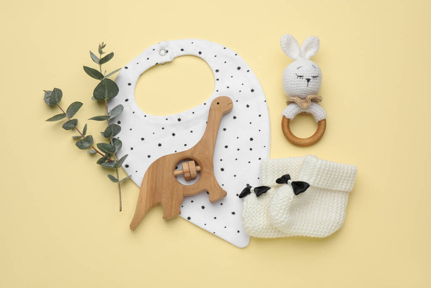 Flat lay composition with baby accessories and bib on yellow background - Fotó, kép
