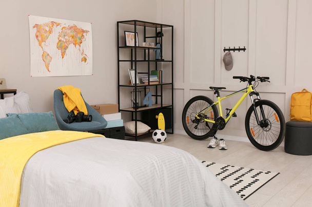 Stylish teenager's room interior with comfortable bed and sports equipment - Φωτογραφία, εικόνα