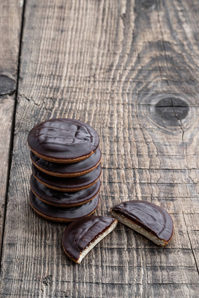 Jaffa  cake cookies covered with dark chocolate and filled with marmalade on wooden table  - Фото, изображение