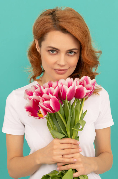 young woman with tulip flower bouquet on blue background - Zdjęcie, obraz