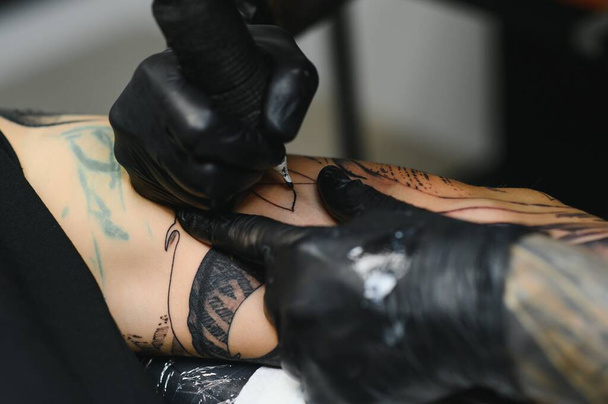 Professional tattoo artist working in his tattoo studio. - Valokuva, kuva