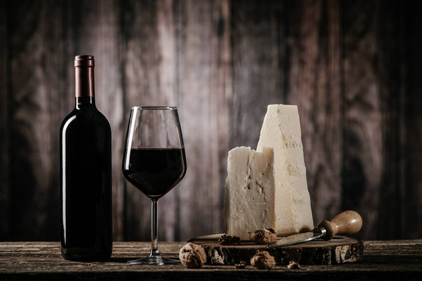  Cheese and wine on old wooden table close u - Foto, immagini
