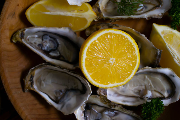 fresh oysters, lemon on wooden background - Foto, Imagen