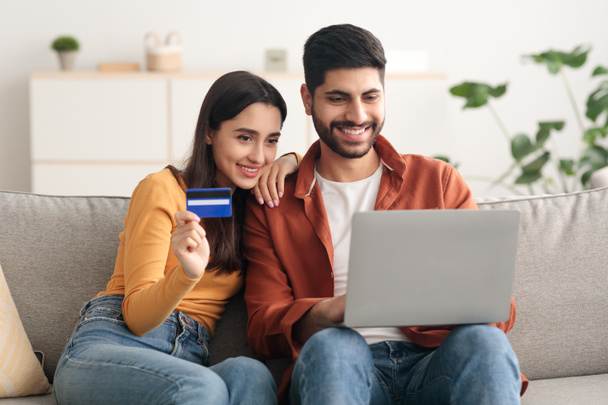 Çevrimiçi Alışveriş yapan Arap Çifti Laptop ve Kredi Kartlarını İçerde Kullanıyor - Fotoğraf, Görsel