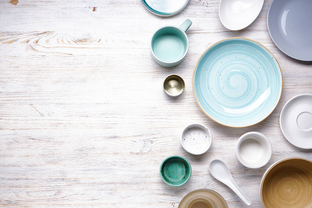 Сучасні керамічні та дерев'яні посуд, модний посуд з місцем для тексту. Страви для подачі їжі на дерев'яному фоні, вид зверху
.  - Фото, зображення