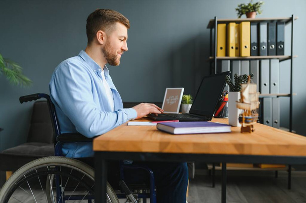 Handicapped Businessman Sitting On Wheelchair And Using Computer In Office - Foto, Bild