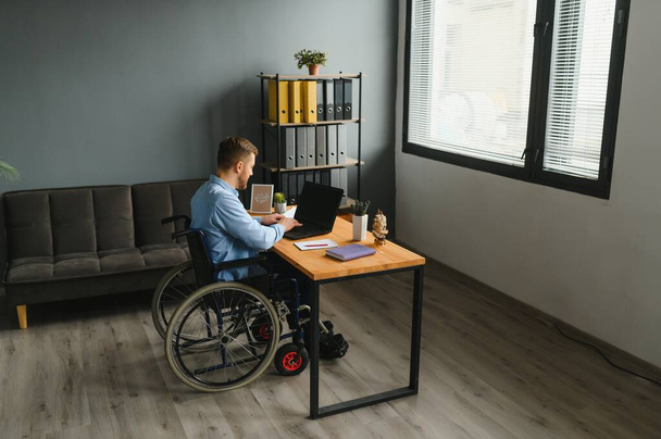 Man in wheelchair at home or in office. - Foto, Imagem