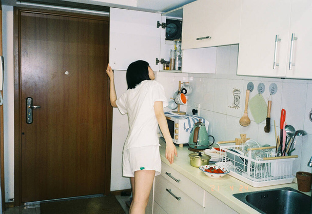young woman in a kitchen sink with a spoon - Photo, Image