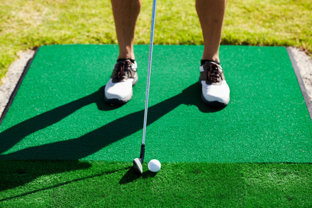 Abschlagen. Zugeschnittenes Bild eines Golfers, der kurz vor dem Abschlag steht. - Foto, Bild
