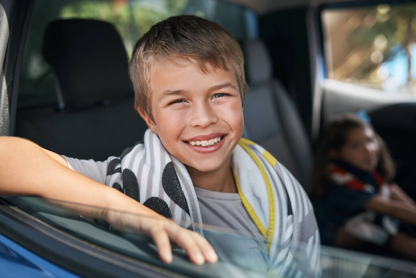 Připraven na výlet. Vystřižený portrét mladého chlapce sedícího v autě před cestou na výlet se svou rodinou. - Fotografie, Obrázek