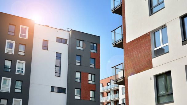 Nowoczesna europejska architektura mieszkaniowa w słoneczny dzień. Wygląd nowego wielopiętrowego budynku mieszkalnego. Koncepcja sprzedaży i wynajmu mieszkań dla konsumentów.Nowoczesne okna i balkony. - Zdjęcie, obraz