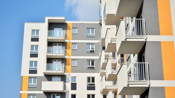 Nowoczesna europejska architektura mieszkaniowa w słoneczny dzień. Wygląd nowego wielopiętrowego budynku mieszkalnego. Koncepcja sprzedaży i wynajmu mieszkań dla konsumentów.Nowoczesne okna i balkony. - Zdjęcie, obraz