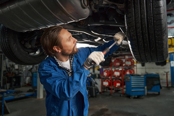 Close-up photo of car mechanic working at service station - 写真・画像