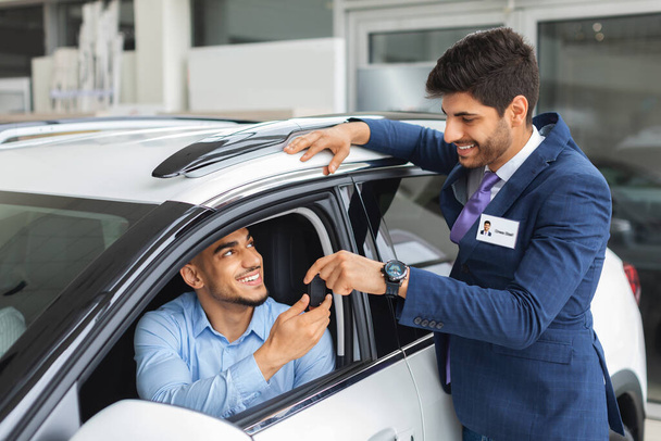 Vidám értékesítési menedzser ad autó kulcs a tulajdonos - Fotó, kép