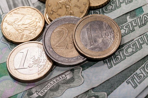 Euro-érmék a háttér egy ezer rubelt bankjegyek - Fotó, kép